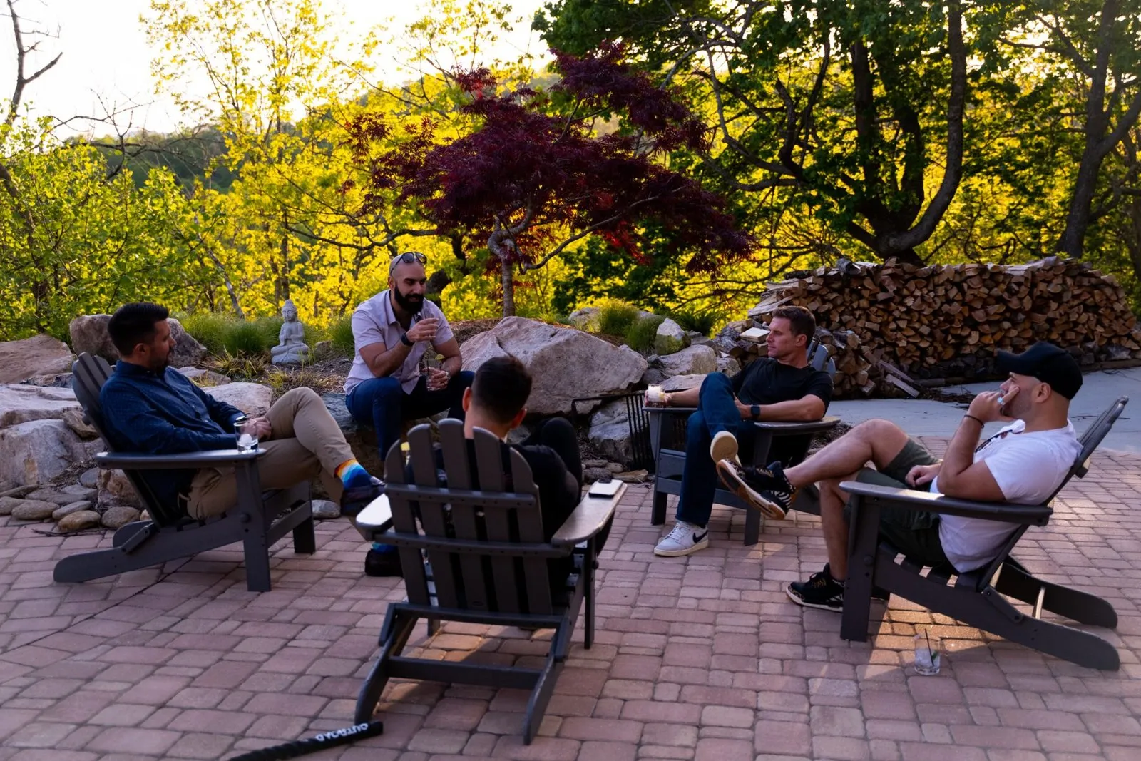 Guests seated outdoors on a garden patio at the Agoge Consulting CEO mastermind