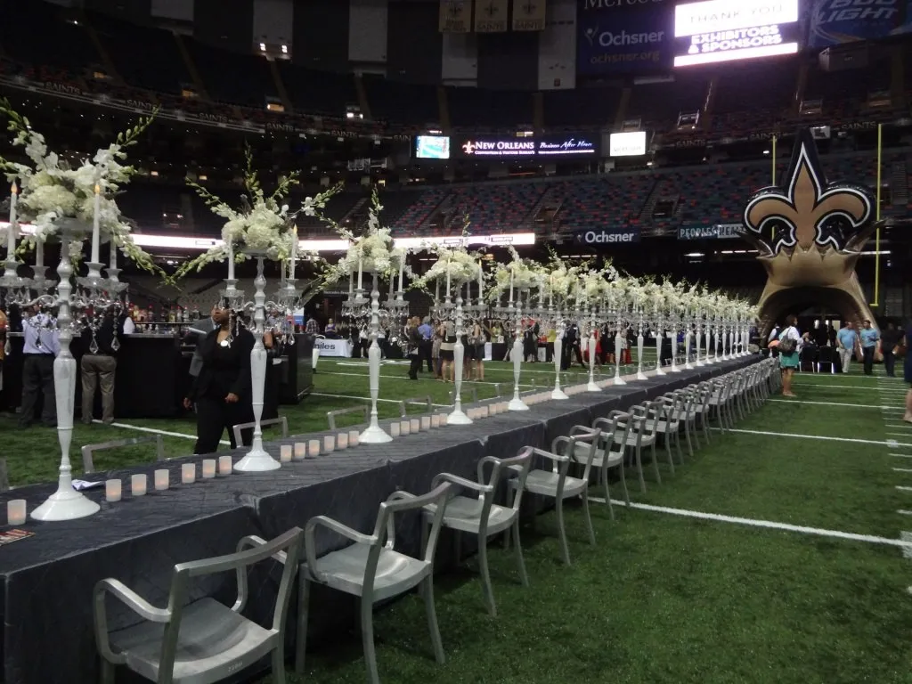 Long dinner tables set on the field of a stadium