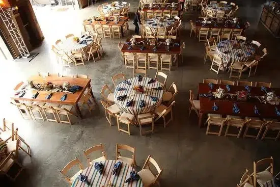 Overhead view of dinner tables set with striped linens and wooden chairs
