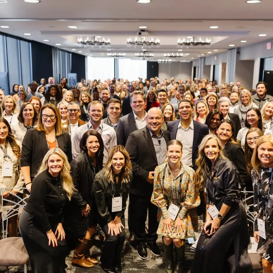 Large group of attendees posing together at a corporate program