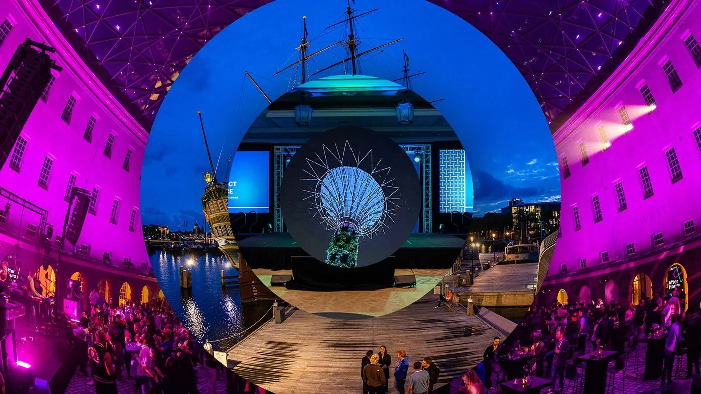 Immersive general session with arched stage projection and a seated audience