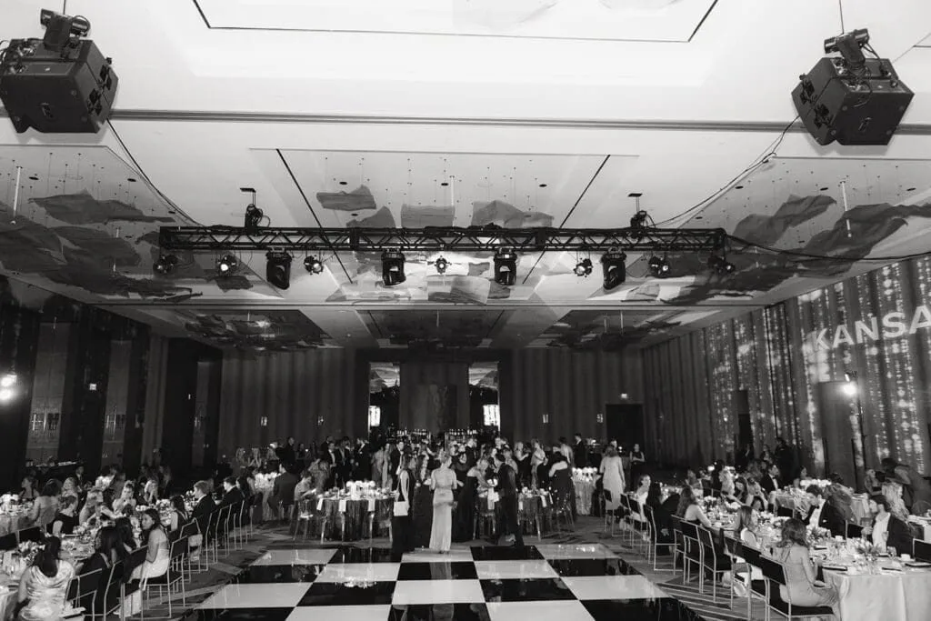 Black and white ballroom with a checkered dance floor and round tables