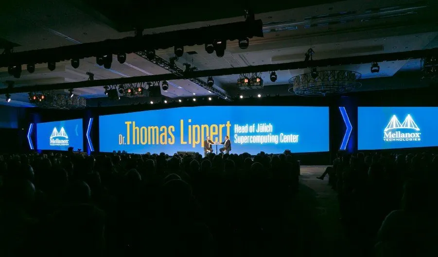 Large conference hall with a wide stage and branded screens