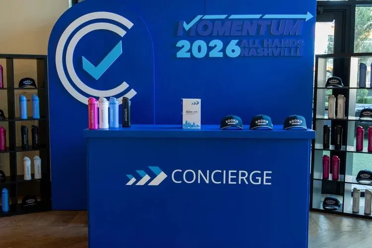 Branded concierge desk with a blue backdrop at an all hands event