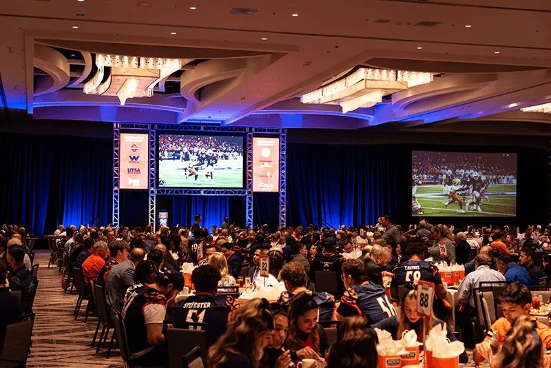 Guests seated at round tables in a ballroom for a luncheon