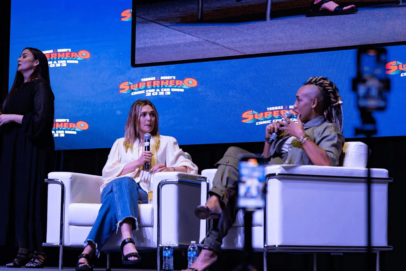 Panel of speakers seated on a summit stage before an audience
