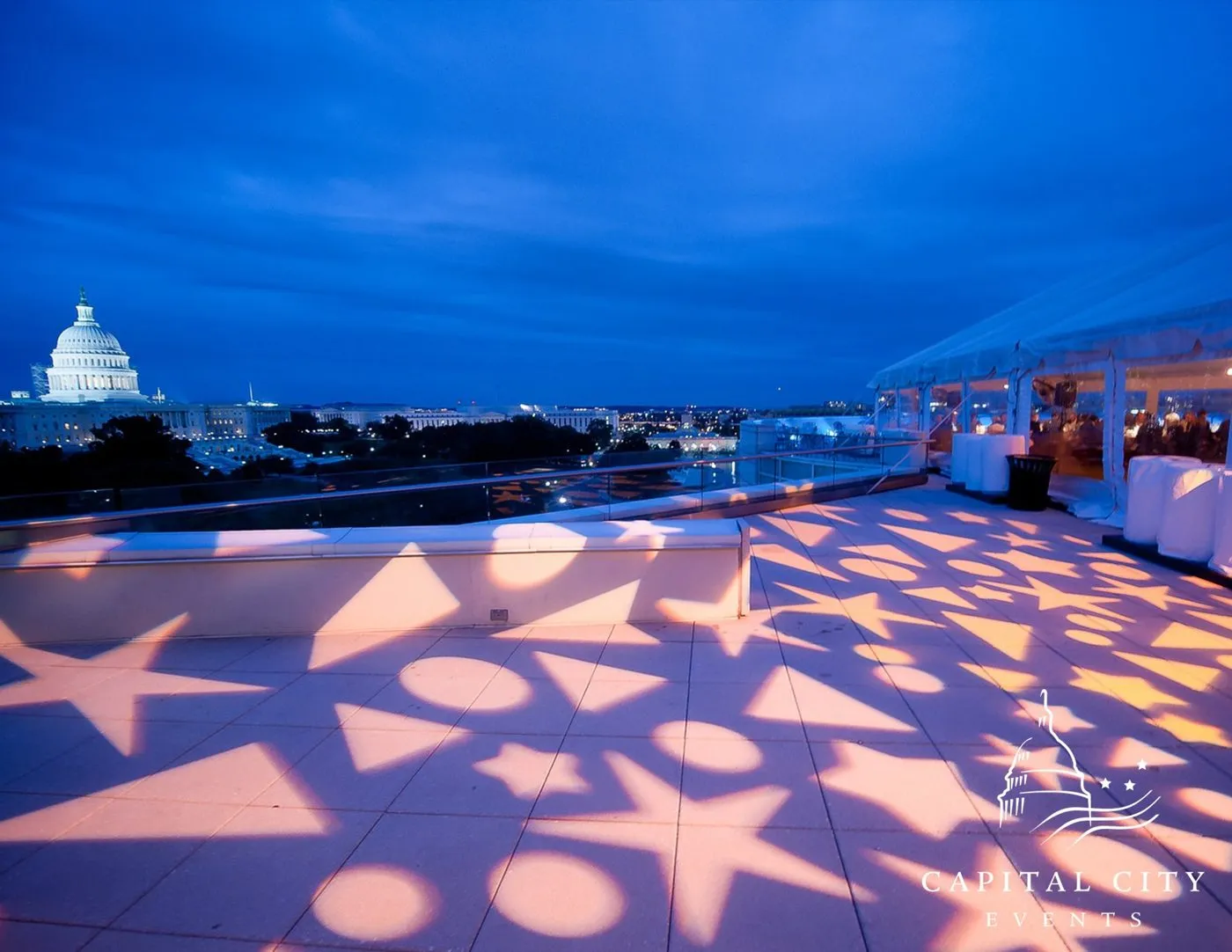 Rooftop event at dusk with patterned lighting and the Capitol dome in the background