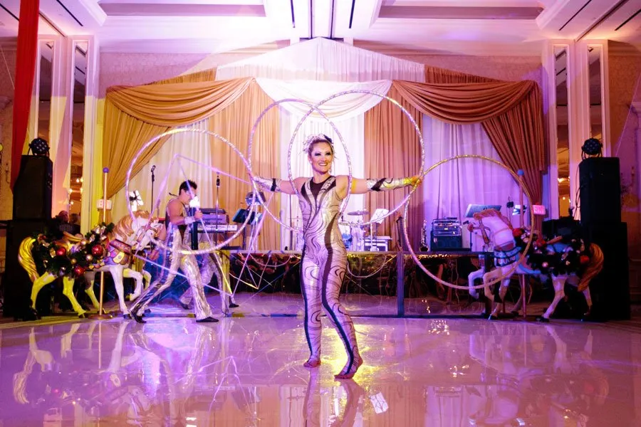 Circus performers on the dance floor at a holiday party in a Dallas hotel ballroom