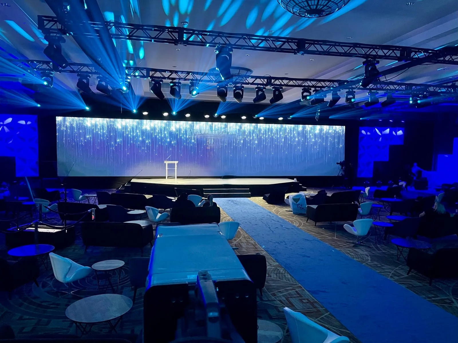 Ballroom with a wide LED wall, lighting truss and blue stage lighting