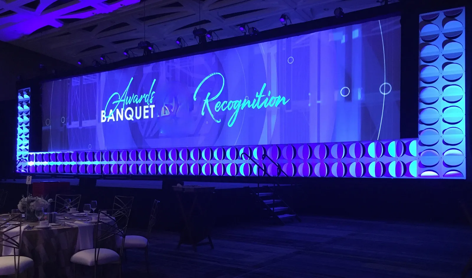 Awards banquet and recognition event with a wide LED wall and lit stage