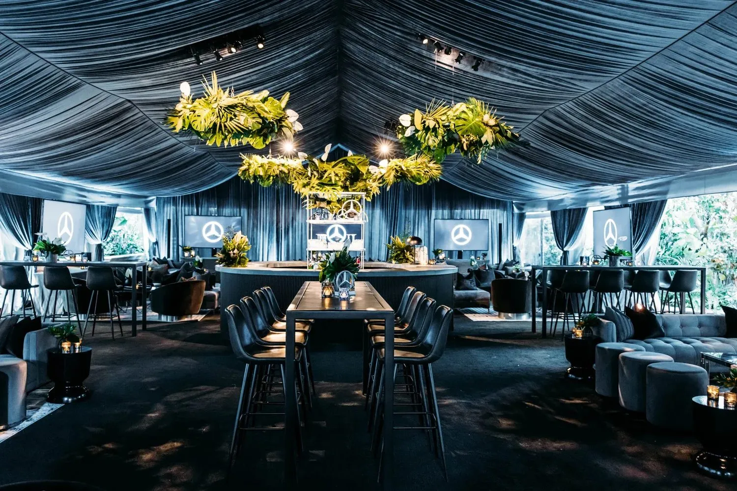 Tented dining tables with yellow floral arrangements overhead
