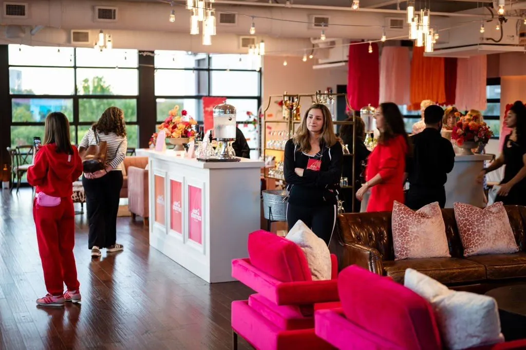 Branded pop up lounge with a white bar and hot pink sofas at a company event