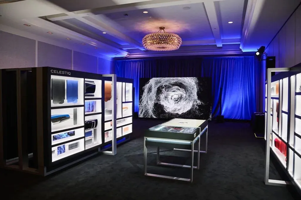 Product display cabinets and a large screen in a darkened event room with blue lighting