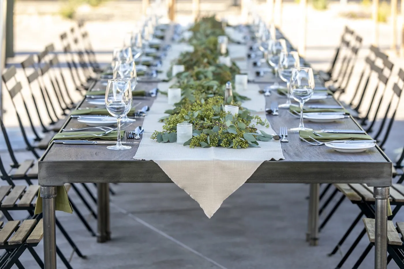 Long outdoor dining table set for a group dinner on a hotel patio