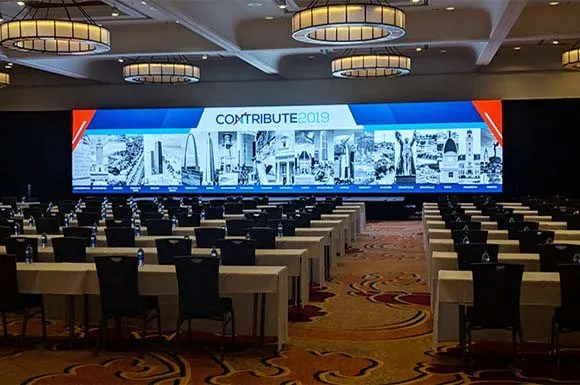 Conference ballroom with classroom seating facing a long LED screen