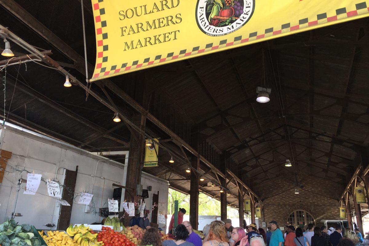 Produce and shoppers under the roof of the Soulard Farmers Market.