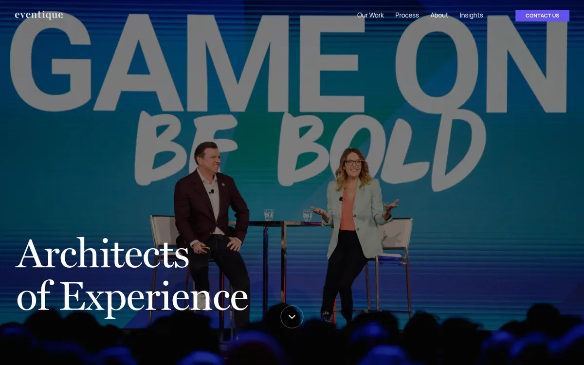 Eventique homepage hero showing two speakers seated on a conference stage in front of a big screen reading Game On Be Bold, with the overlay headline Architects of Experience and the audience in silhouette