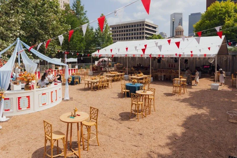 Outdoor company event set with striped tents and flags