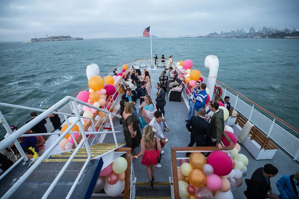Guests on a balloon-decorated boat deck on San Francisco Bay