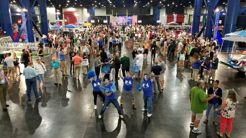 Large group taking part in an organized activity inside a convention hall