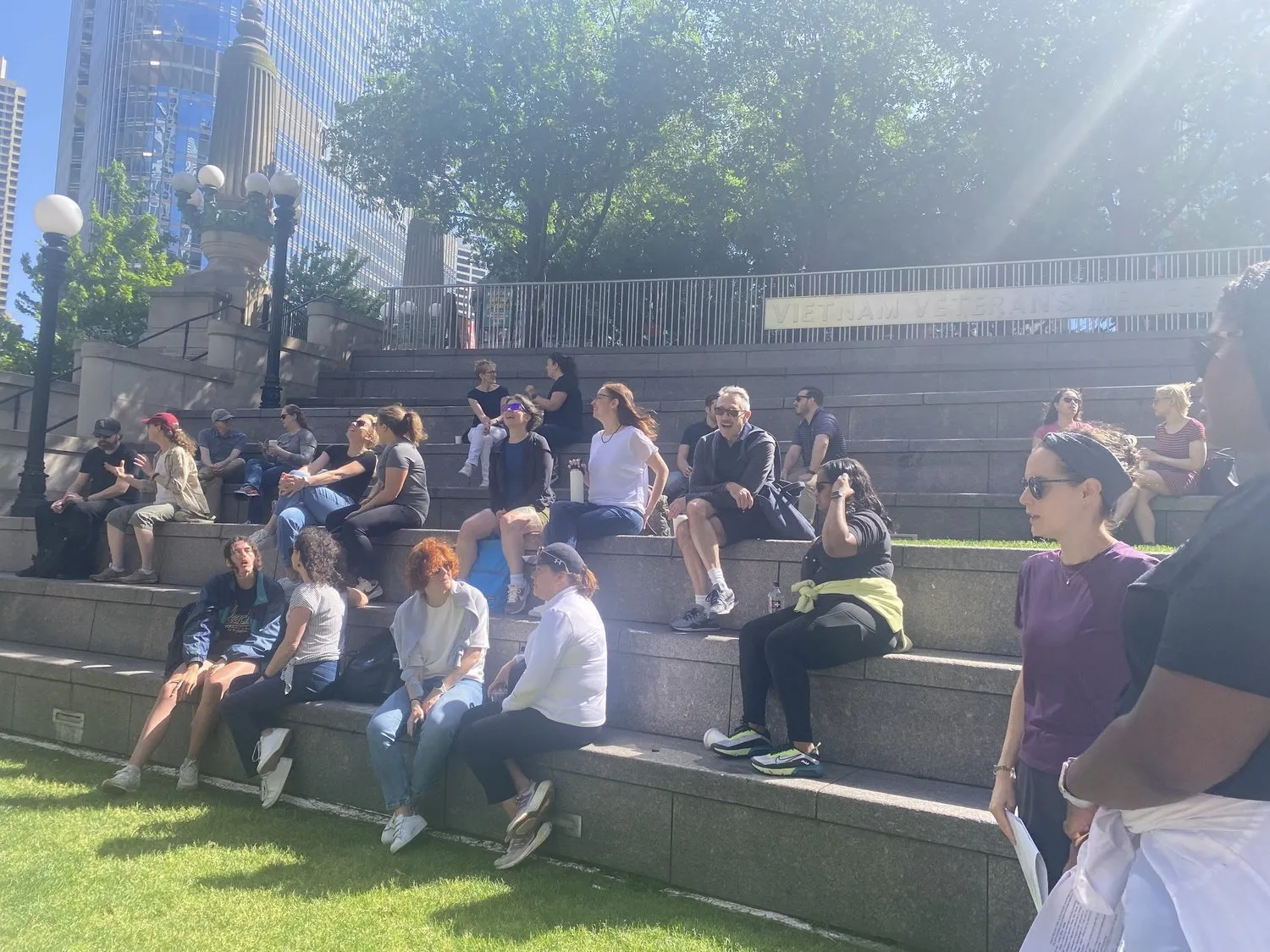 Team seated on outdoor amphitheater steps during a SUM session