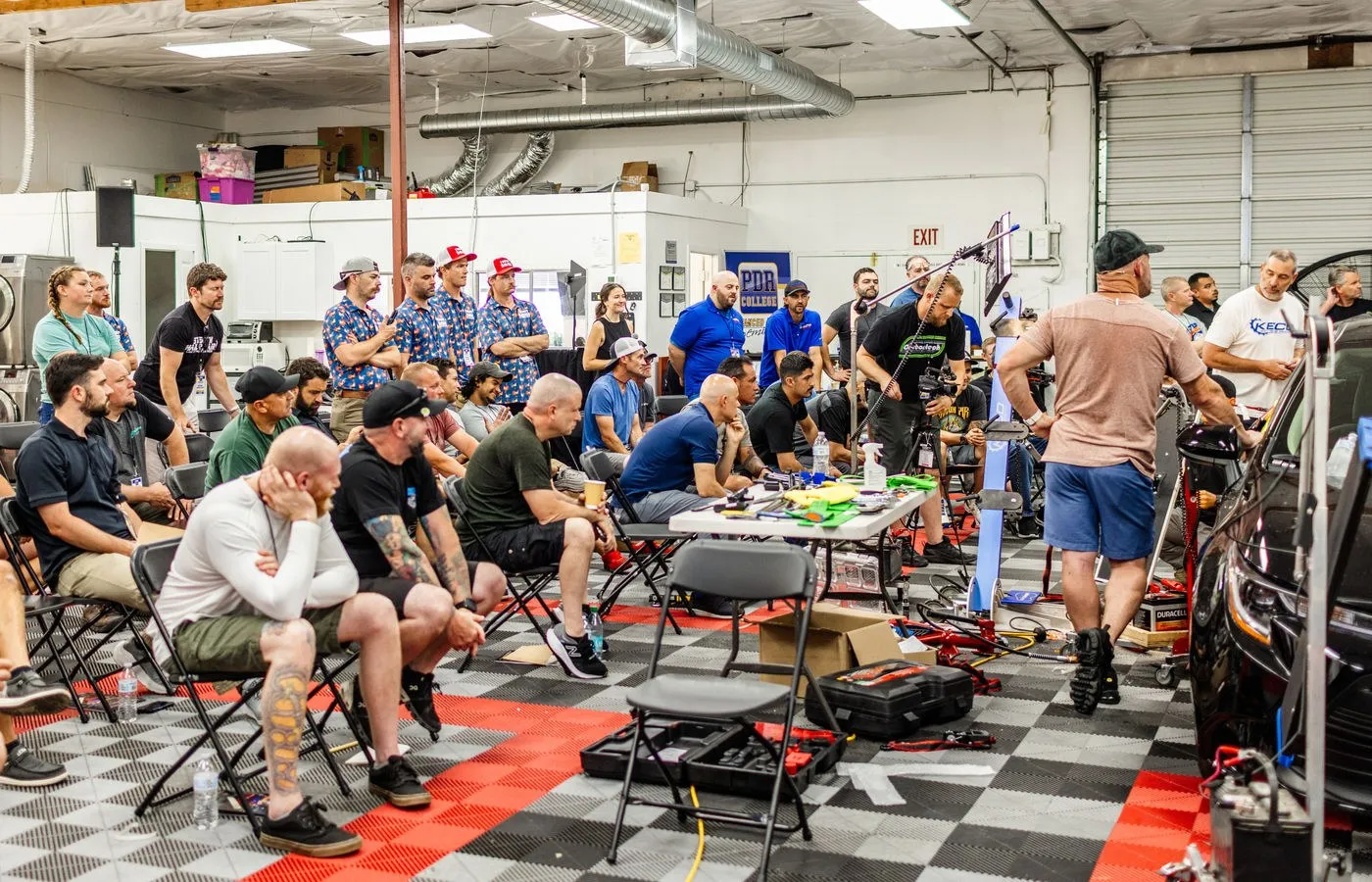 Seminar attendees seated in a garage workshop watching a demonstration