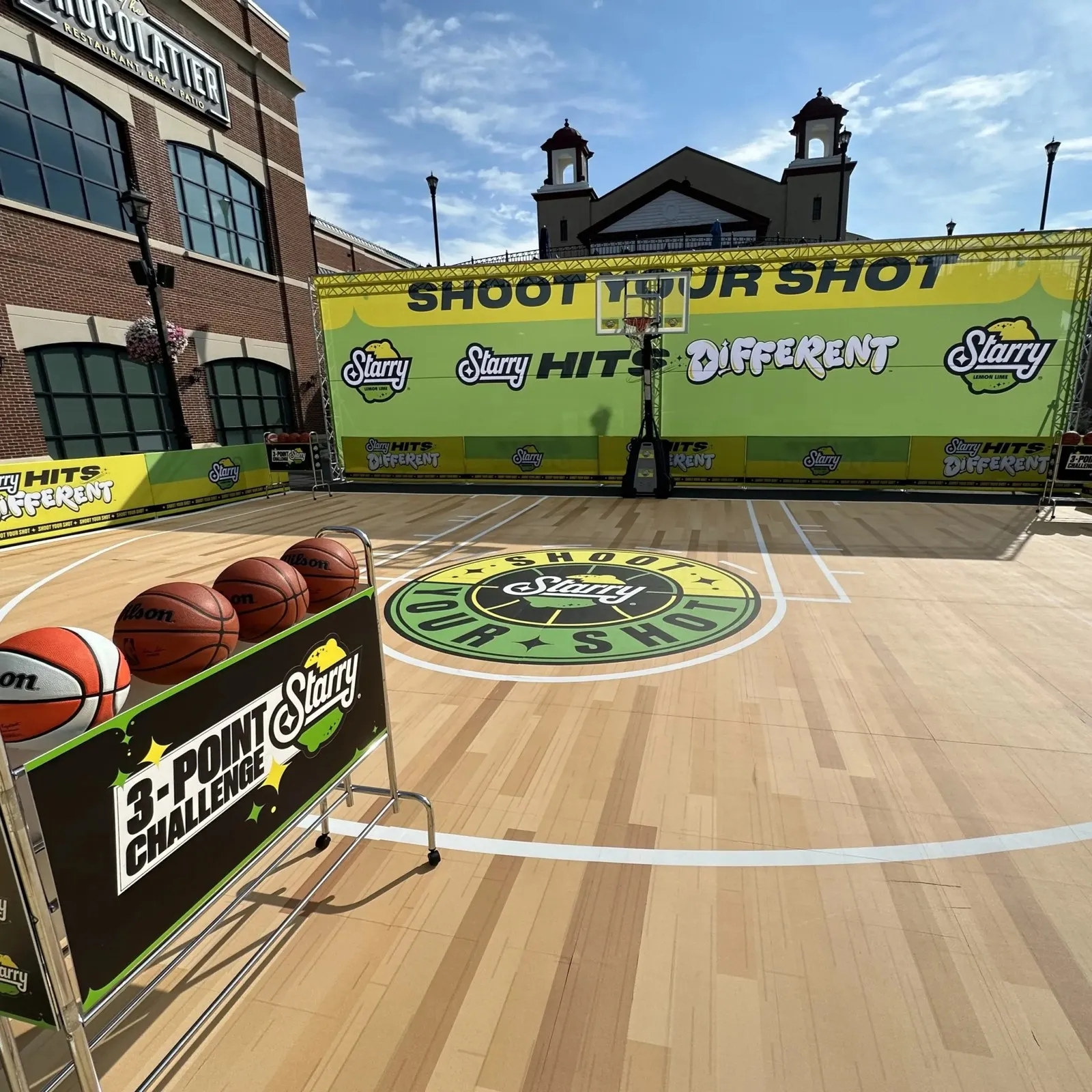 Outdoor basketball brand activation with a "Shoot your shot" banner