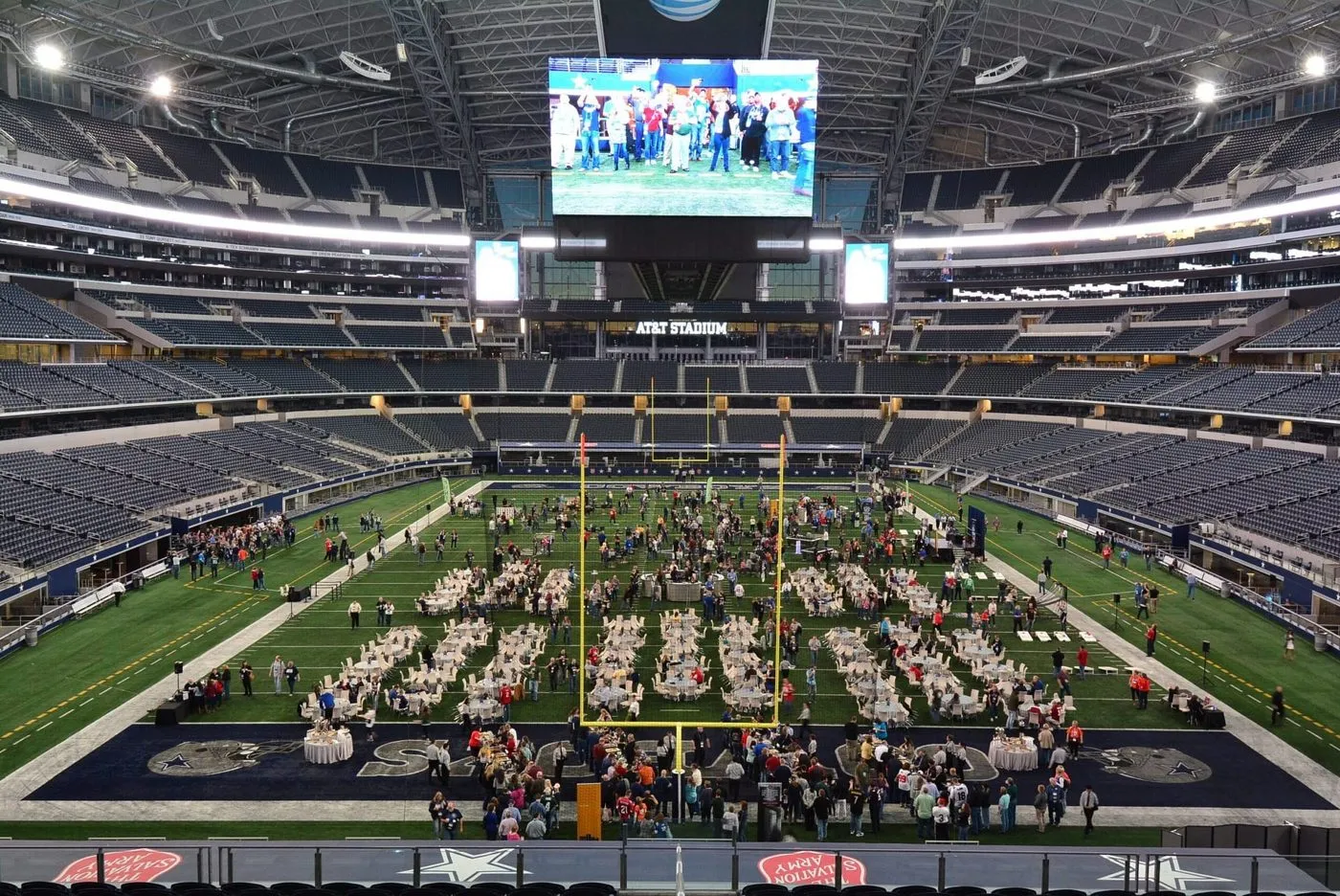Stadium field set with round tables for a large corporate gathering