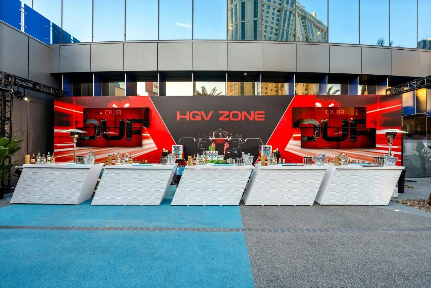 Branded activation zone with red bar fronts and white lounge seating outdoors