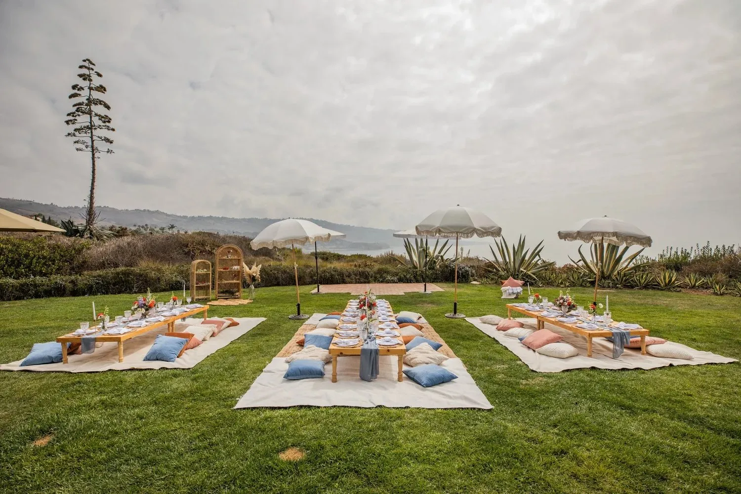 Picnic tables set on an oceanfront lawn for a company offsite at Terranea