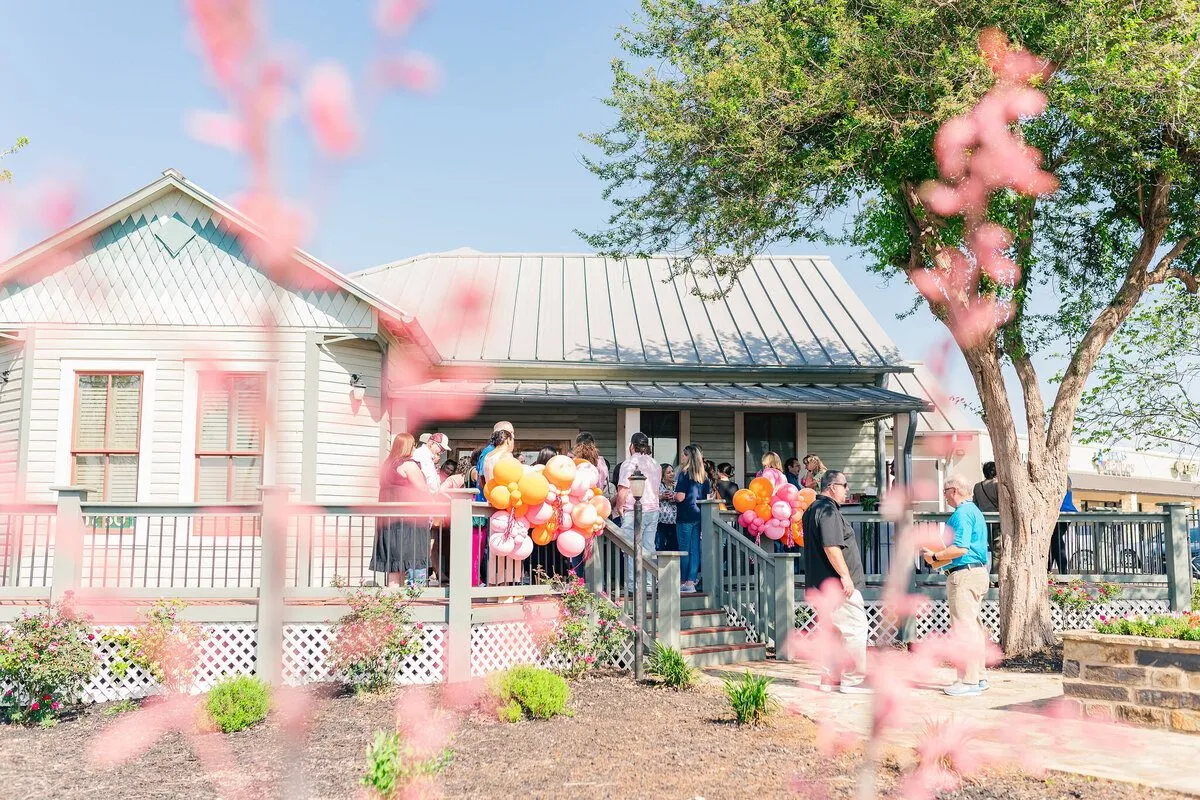 Guests gathered outdoors near a small building decorated with confetti