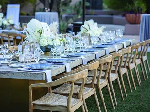 Long dinner table with white florals on a patio at an Arizona event