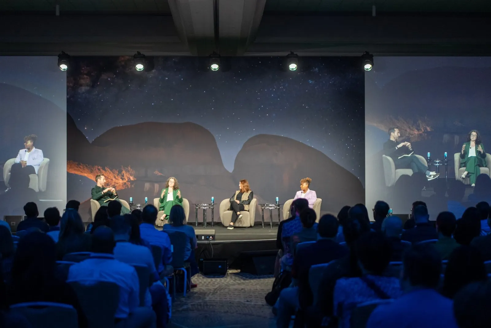 Panel discussion on a conference stage before a large audience