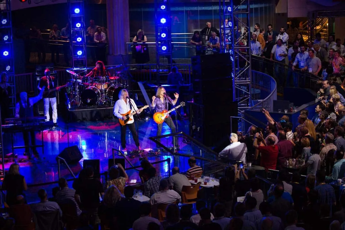 Live band performing for a crowd under blue and white stage lighting
