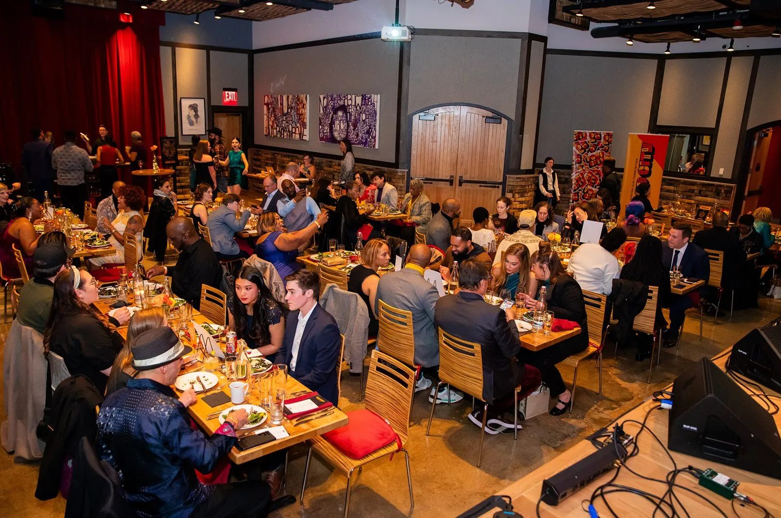 Hall of guests seated at long communal dinner tables