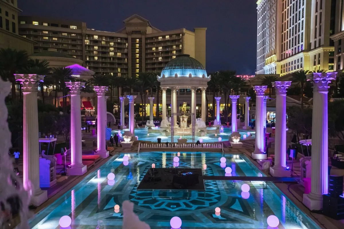 Event set around an illuminated pool and colonnade at night