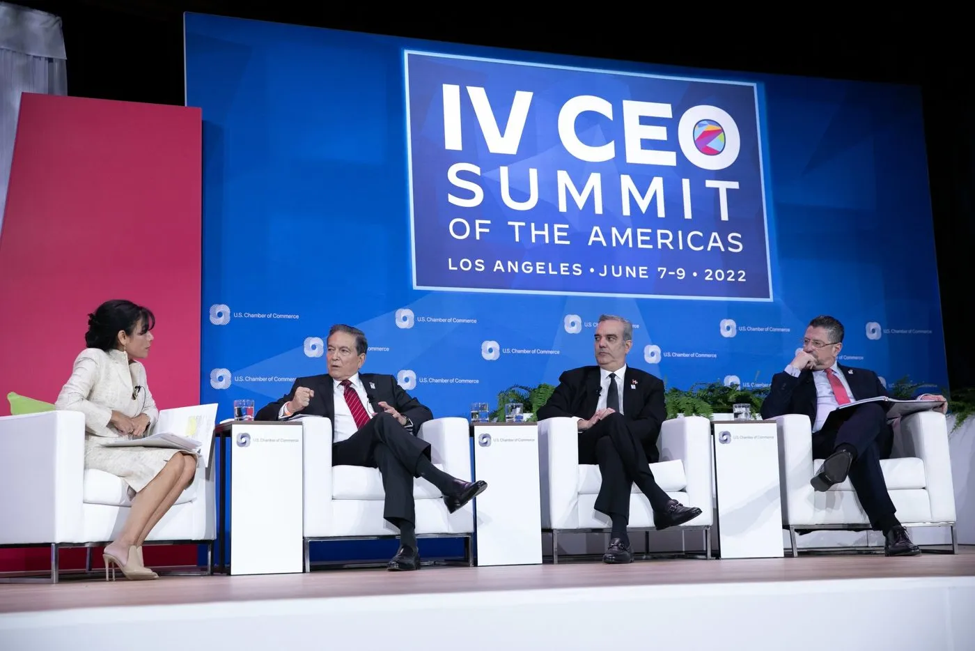 Panel discussion on a conference stage with a summit backdrop