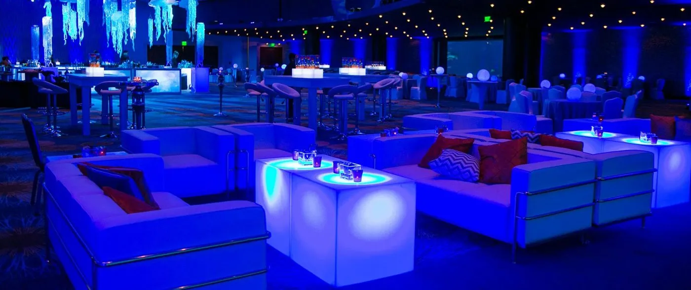 Blue lit lounge furniture set up for a corporate evening reception