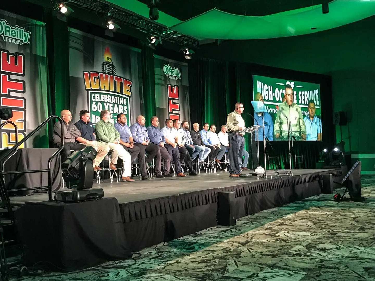 Panel seated on a staged set in front of conference screens