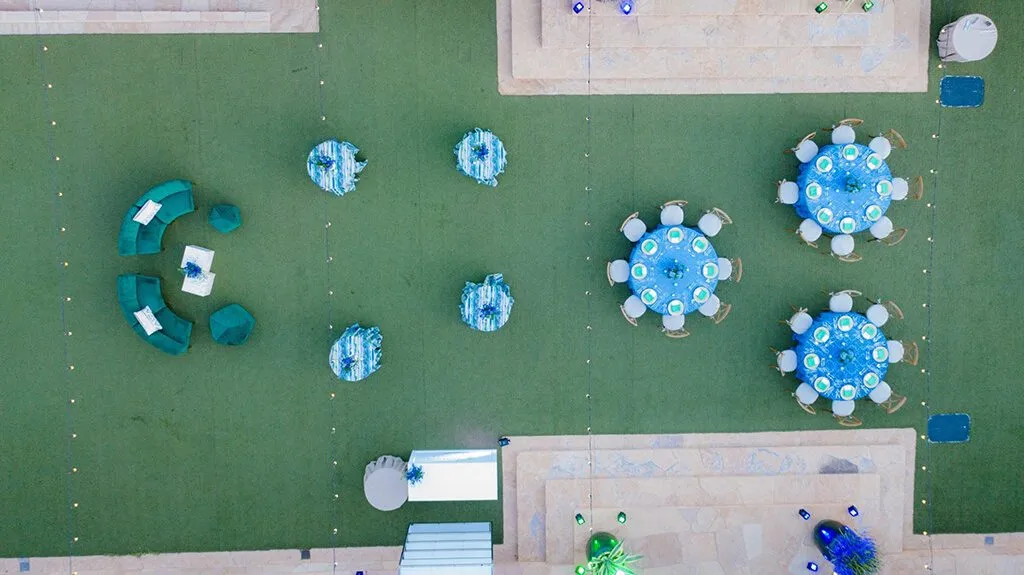 Aerial view of a lawn event layout with round tables and lounge seating