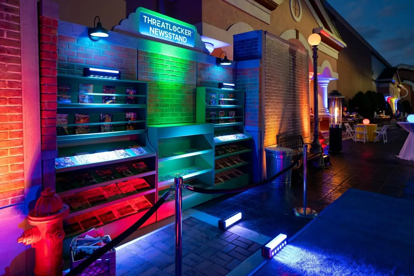 Illuminated bar shelving and lounge area lit in green, blue and orange at night