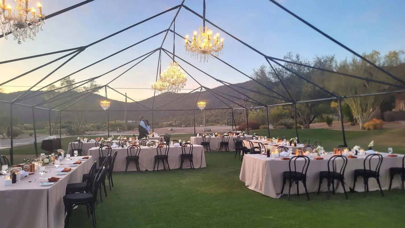 Tented dinner tables set on a lawn for a corporate retreat