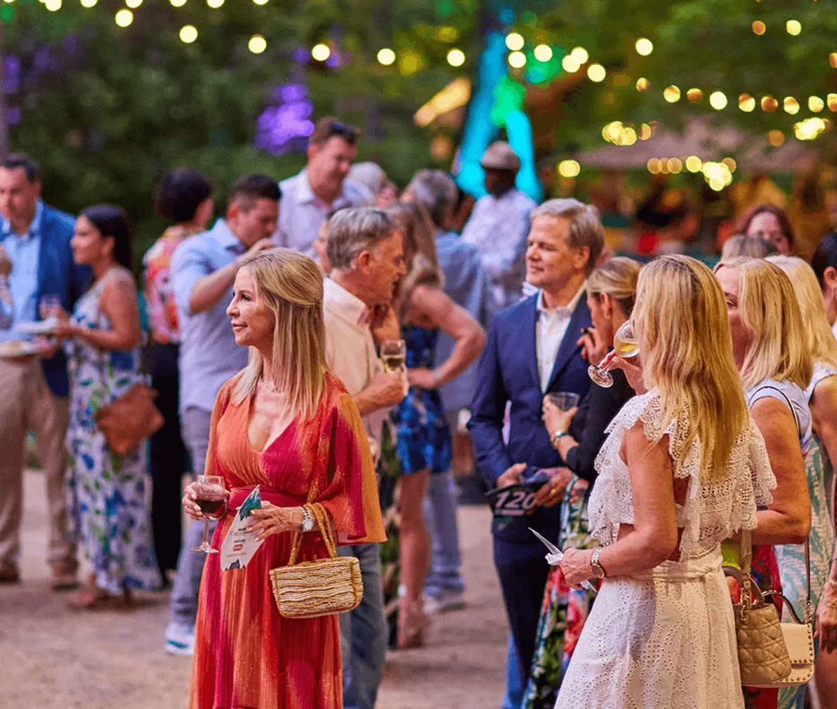 Guests mingling at an evening reception under string lights
