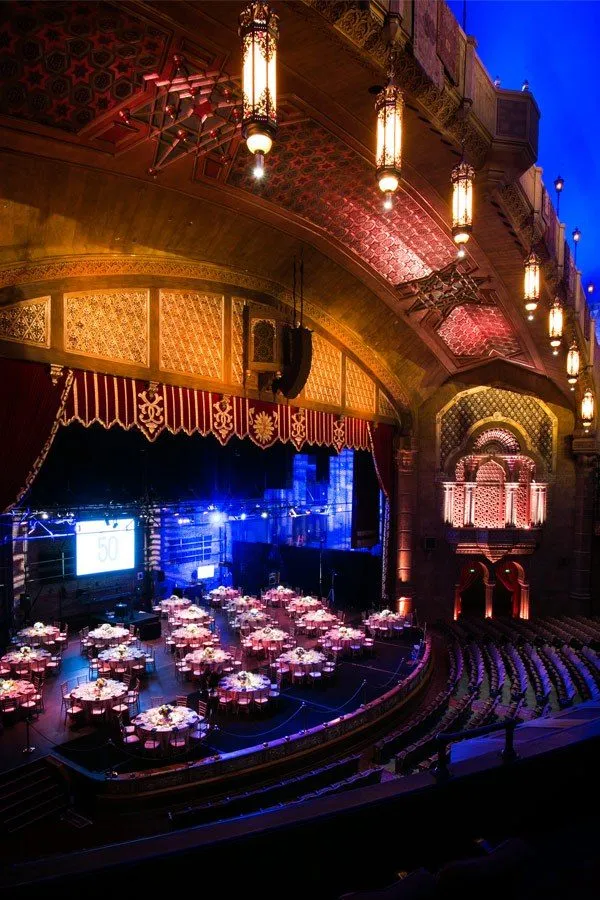 Banquet tables set for a group dinner inside a historic theater