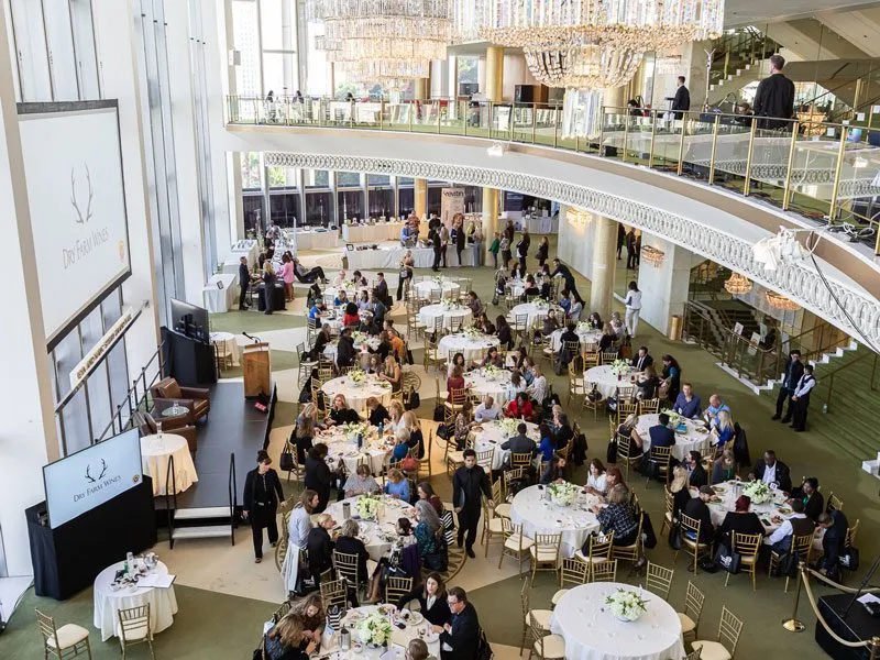 Round tables in a bright atrium with an upper balcony