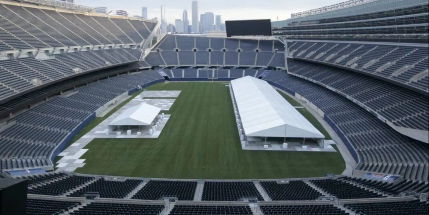 Stadium field with two large event tents set up for a corporate program