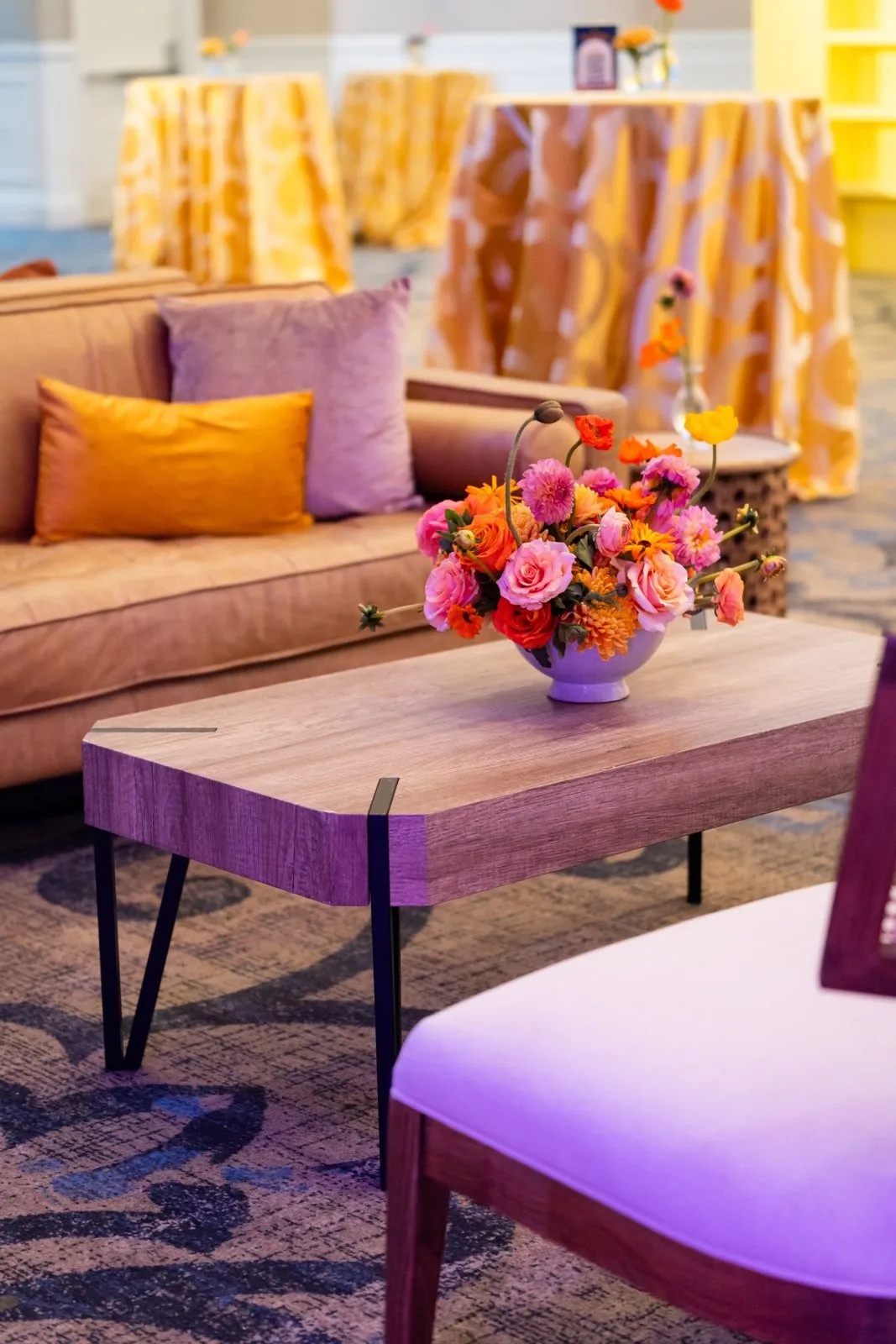 Lounge seating with a colorful floral arrangement at a corporate event