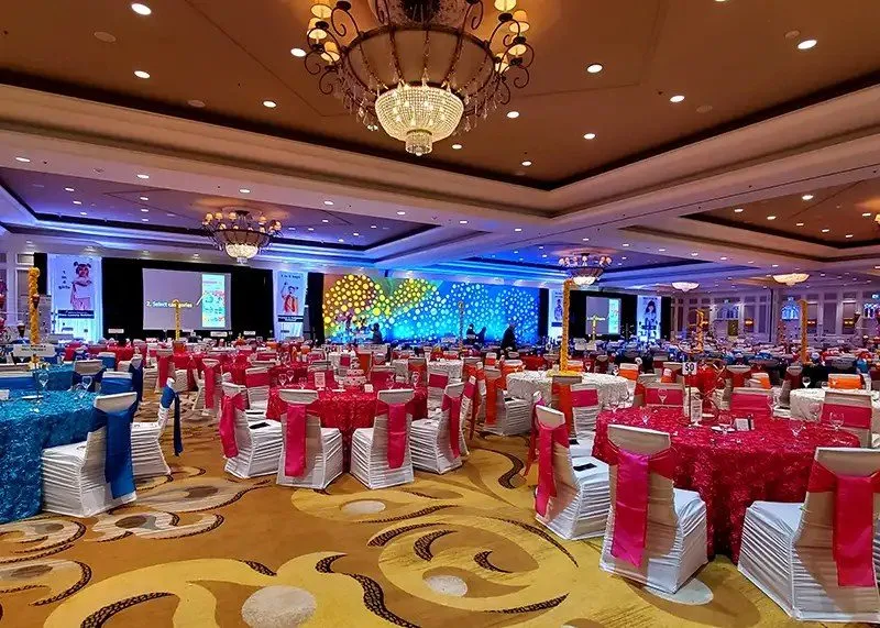 Gala ballroom with stage screens and decorated tables
