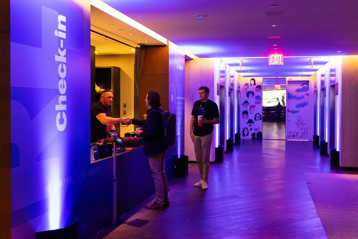 Roadshow check-in with branded signage and uplighting