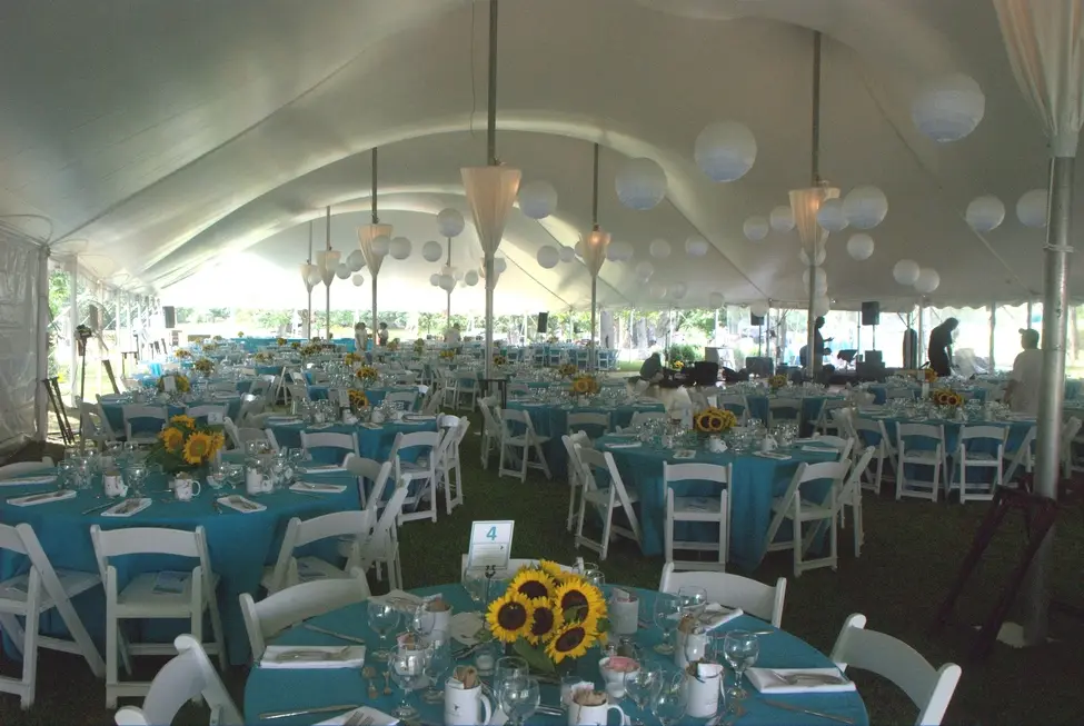 Tented fundraising gala with round tables and sunflower centerpieces